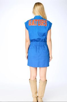 a woman in a blue shirt dress with the word gators on it's back