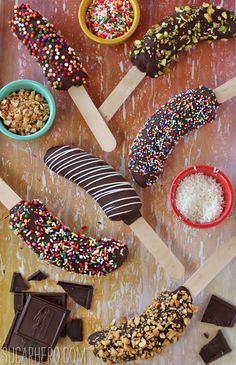 chocolate covered donuts and other desserts on wooden sticks with sprinkles