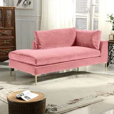 a pink couch sitting on top of a white rug