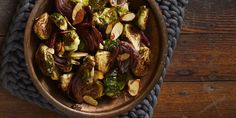 a bowl filled with brussel sprouts and almonds on top of a table