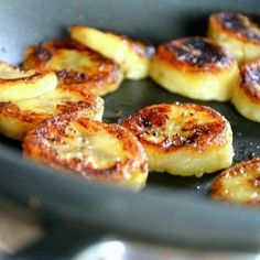 bananas frying in a pan on top of a stove with other food items cooking