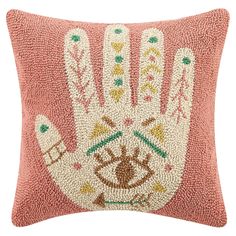 a pink pillow with an embroidered hand on the front and side, which is made from beads