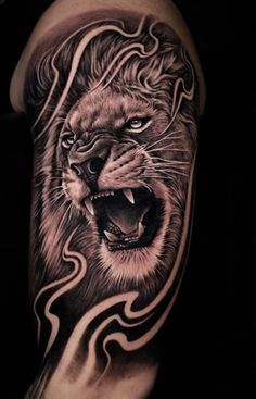 a man's arm with a black and white tattoo of a lion on it