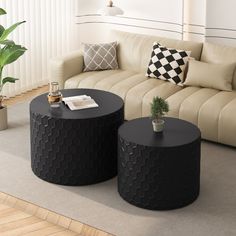 two black round tables sitting on top of a carpeted floor next to a couch