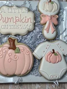 decorated cookies in the shape of baby's first pumpkins and onesuits