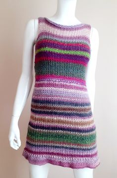 a white mannequin wearing a multicolored knitted dress