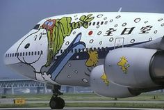 an airplane with cartoon characters painted on it's side and the words happy new year of dog at charlie brown cafe