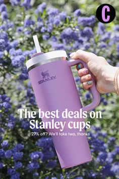 a person holding a purple cup with the words stanley on it and an image of blue flowers in the background