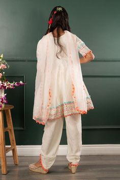 Off white three fourth sleeves kurta with mirror work embroidery on border and pom pom detailing. Paired with pom pom detailing petal hem dhoti pant and dupatta.
Components: 3
Pattern: Embroidered
Type Of Work: Mirror Work, Pom Pom
Neckline: Round
Sleeve Type: Three Fourth
Fabric: Pure Chanderi Silk, Dola Silk, Organza; Lining: Mul Mul Cotton
Color: Off White
Other Details: 
Closure: 
Kurta: Back zip
Dhoti pant: Elasticated
Note: The hair accessory and potli bag shown in the image is not for sal Festive Spring Dupatta With Mirror Work, Festive Sets With Tassels And Straight Kurta, Festive Straight Kurta Sharara With Tassels, Festive Sharara With Tassels And Straight Kurta, Navratri Straight Kurta Anarkali Set With Tassels, Navratri Anarkali Set With Tassels And Straight Kurta, Festive Off White Sets With Straight Kurta, Festive Off-white Sets With Straight Kurta, Navratri Straight Kurta Sets With Tassels