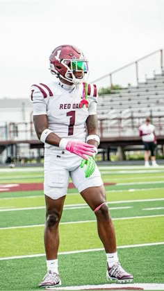 a man standing on top of a field wearing a football uniform and holding a glove