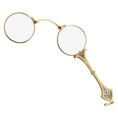 a pair of round glasses sitting on top of each other with gold rimmed frames