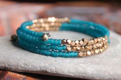 Kalimantan Stacking Memory Wire Bangle Bracelet with Matte Teal Glass and Faceted Brass Beads - Exotic and Chic Turquoise Beaded Bracelets With Faceted Beads For Festival, Festival Turquoise Beaded Bracelets With Faceted Beads, Bohemian Turquoise Stretch Bracelet With Faceted Beads, Unique Turquoise Beaded Bangle Bracelet, Turquoise Wrap Bracelet With Faceted Beads As Gift, Turquoise Wrap Bracelet With Faceted Beads, Spiritual Turquoise Beaded Bracelets With Tiny Beads, Spiritual Turquoise Beaded Bracelet With Tiny Beads, Spiritual Turquoise Bracelets With Tiny Beads