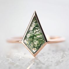 Moss agate ring with a kite-cut geometric shaped green mossy gemstone in a bezel setting. Unique modern engagement solitaire with an organic tone and simple statement design. We are the original jewelry designers to use moss agate and create geometric moss agate one of a kind jewelry. Please beware of other jewelry designers using moss agate as their designs are replicas of our bestsellers and cannot match our high standards of production and authentication of quality. The prices listed are for Engagement Rings Simple Unique, Kite Engagement Ring, Moss Agate Rings, Kite Ring, Agate Rings, Agate Engagement Ring, Moss Agate Ring, Moonstone Engagement, Moonstone Engagement Ring