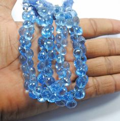 a hand holding some blue beads on it