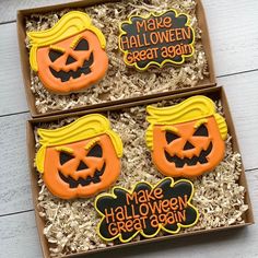 three decorated halloween cookies in a box on top of some shredded up wood planks