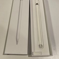 an open box with a pen inside and in the bottom, next to it is a white ballpoint pen