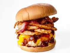 a bacon cheeseburger on a bun with french fries and ketchup is shown in front of a white background