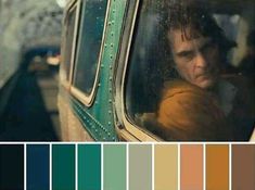 a man sitting in a train looking out the window with color swatches on it