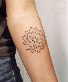 a woman's arm with a tattoo on it that has a flower in the middle