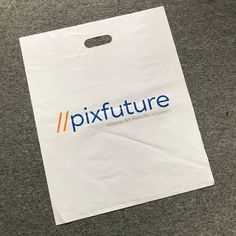 a white paper bag sitting on top of a carpeted floor with the word pixtture printed on it