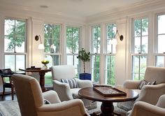 a living room filled with furniture and lots of windows