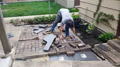 a man is working on some bricks in the yard