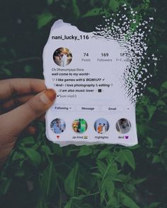 someone holding up a fake instagram card in front of some green plants and bushes