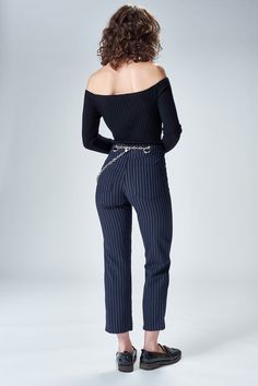 a woman in black and white striped pants with her back to the camera, looking down