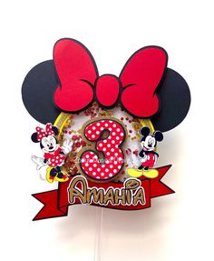 a mickey mouse cake topper with the number 3 on it's face and minnie mouse ears