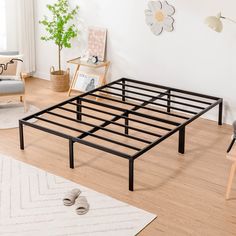 a bed frame sitting on top of a hard wood floor next to a white rug