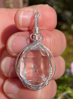 A rare and unique enhydro Herkimer Diamond quartz crystal, artfully wire wrapped in sterling silver. This beautiful pendant features a natural, 15x24 mm, sparkling clear Herkimer Diamond quartz crystal we mined in Middleville NY. The crystal has great form and clarity, a couple tiny baby rider crystals, a small inclusion, a small extra face, and a water cavity with a small bubble that does not move. See all photos and video and look for the small bubble in the center of the crystal. Looks even b Silver Wire-wrapped Sterling Silver Crystal Necklace, Silver Wire Wrapped Sterling Silver Crystal Necklace, Silver Sterling Wire Wrapped Crystal Necklaces, Wire Wrapped Sterling Silver Crystal Necklace In Silver, Clear Wire Wrapped Necklace As Gift, Handmade Crystal Jewelry In Clear, Gift Herkimer Diamond Necklace In Silver, Handmade Clear Crystal Jewelry, Handmade Clear Drop Jewelry