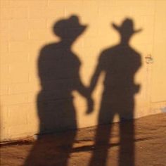 the shadow of two people standing next to each other