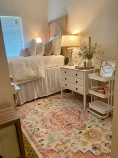 a bed room with a neatly made bed next to a white dresser and a rug