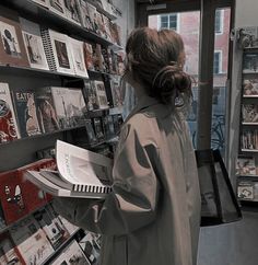 a woman is looking at books in a book store