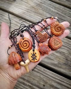 a person's hand holding several different types of beads and pendants on it