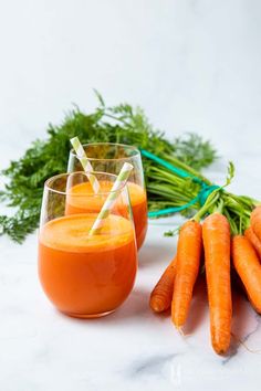 carrots and juice are sitting on the table