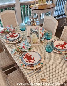 a dining room table set with plates and place settings