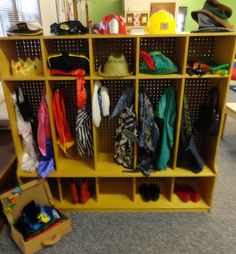 a yellow shelf filled with lots of clothes