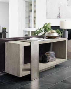 a living room with a couch, table and books on the shelf next to it