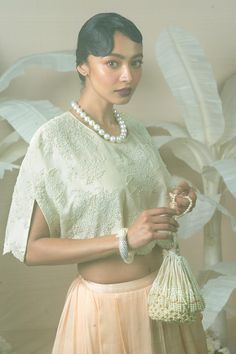 Ivory draped panelled lehenga. Paired with a crop top with pearl and bead embroidery and inner. 
Components: 3
Pattern: Embroidered
Type Of Work: Pearl, Bead
Neckline: Round
Sleeve Type: Asymmetric
Fabric: Modal Satin
Color: Ivory
Other Details: 
Side tassles
Note: Potli bag shown in the image is not for sale.
Occasion: Mehendi and Haldi - Aza Fashions Elegant Festive Crop Top For Wedding, Cream Pre-draped Saree For Reception, Wedding Crop Top With Zari Work, White Lehenga With Traditional Drape For Evening, Anarkali Crop Top For Wedding, Anarkali Style Crop Top For Wedding, Cream Pre-draped Saree For Festive Occasions, White Lehenga For Evening, White Lehenga For Evening Occasion