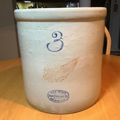 a white ceramic container sitting on top of a wooden table