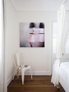 a bedroom with white walls and wooden floors