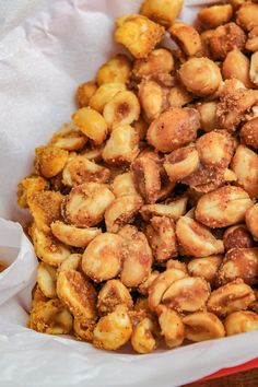 slow cooker sweet and spicy candied peanuts in a white paper bag with text overlay