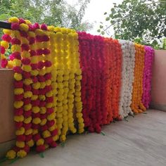 many different colored pom poms are lined up on the side of a building