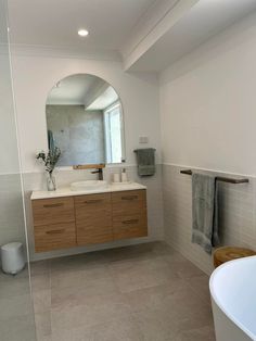 a bathroom with a tub, sink and mirror