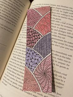 an open book with a colorful tie on it's cover in the shape of a flower