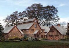 a large wooden house surrounded by trees and grass