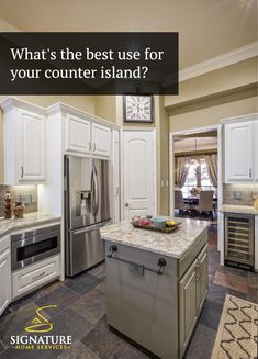 a kitchen with white cabinets and an island in the middle that has a clock on it