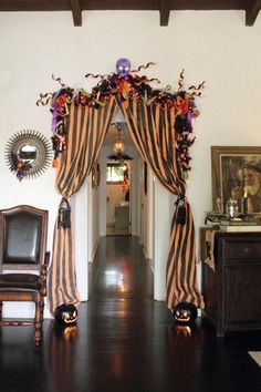 a living room filled with furniture next to a window covered in drapes and curtains