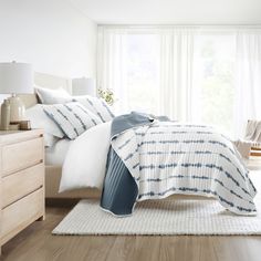 a bedroom with white and blue bedding in it